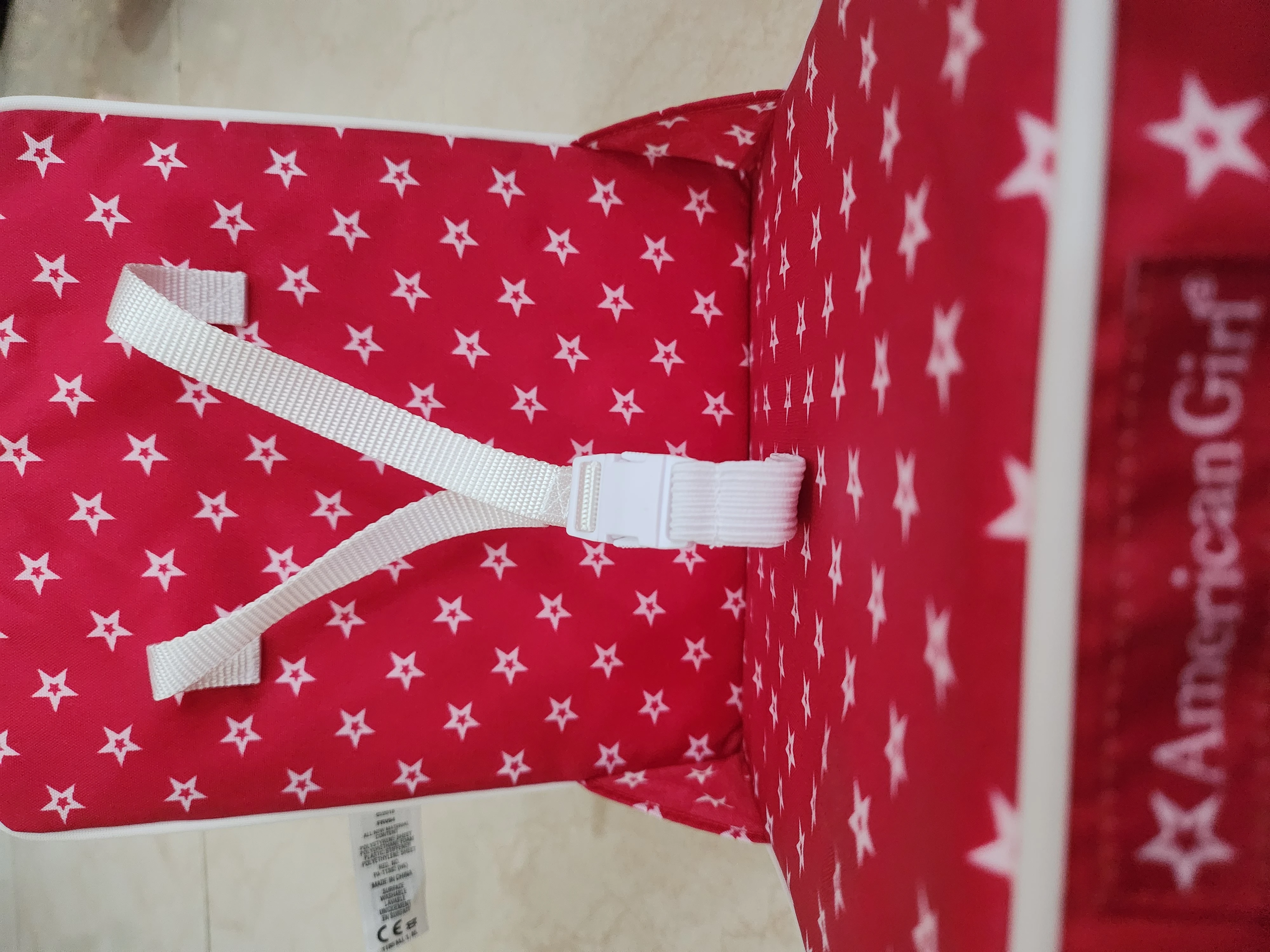 This is an American Girl doll travel or car seat accessory with a red and white star pattern fabric interior 8×8